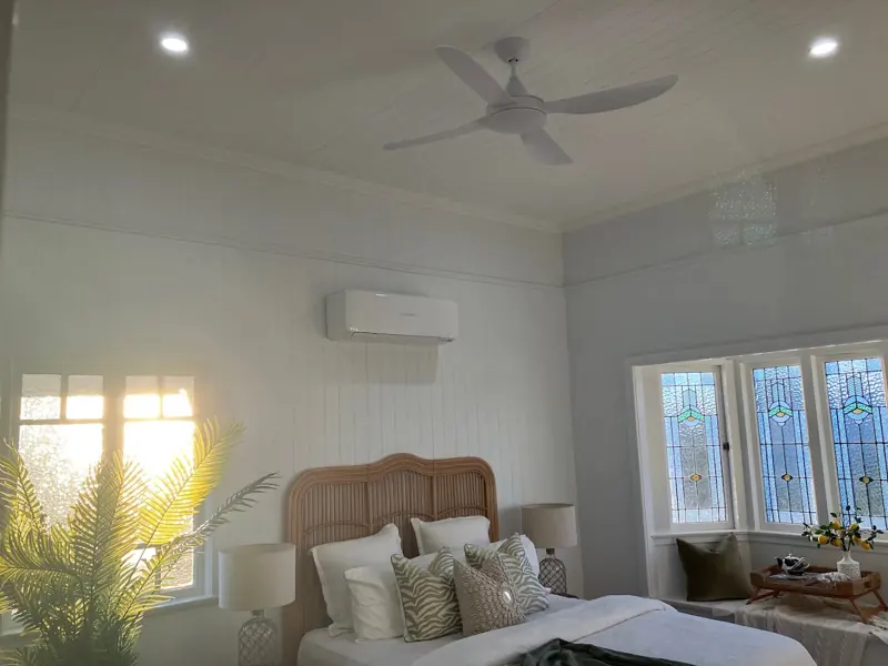Split system air conditioner and ceiling fan in a Queenslander bedroom