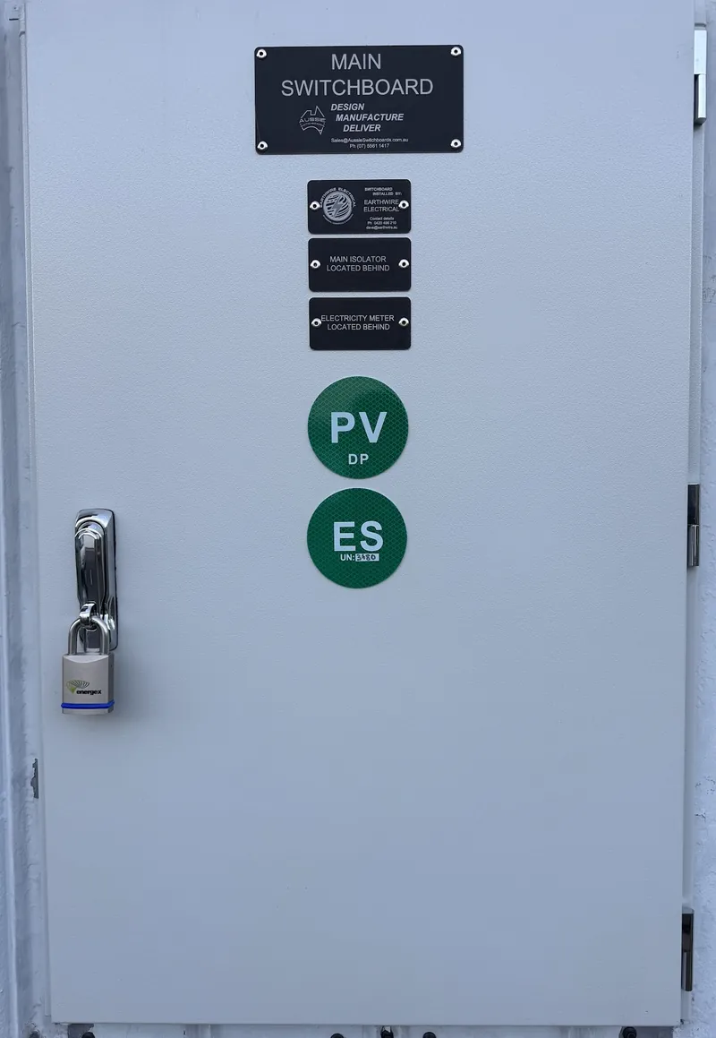 Custom-built main switchboard with labelled isolator, meter and PV signage