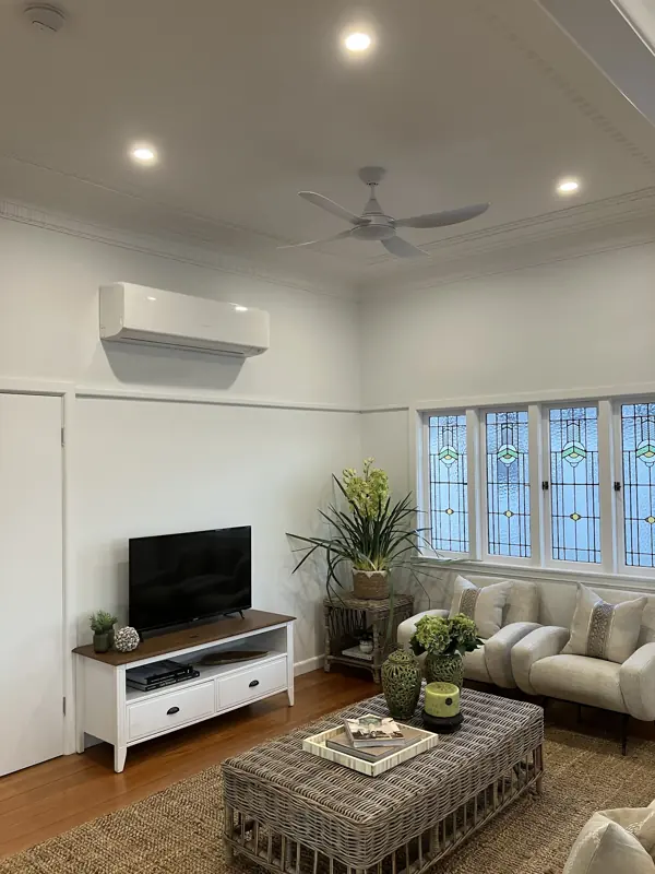 Living room with split system air conditioner and ceiling fan